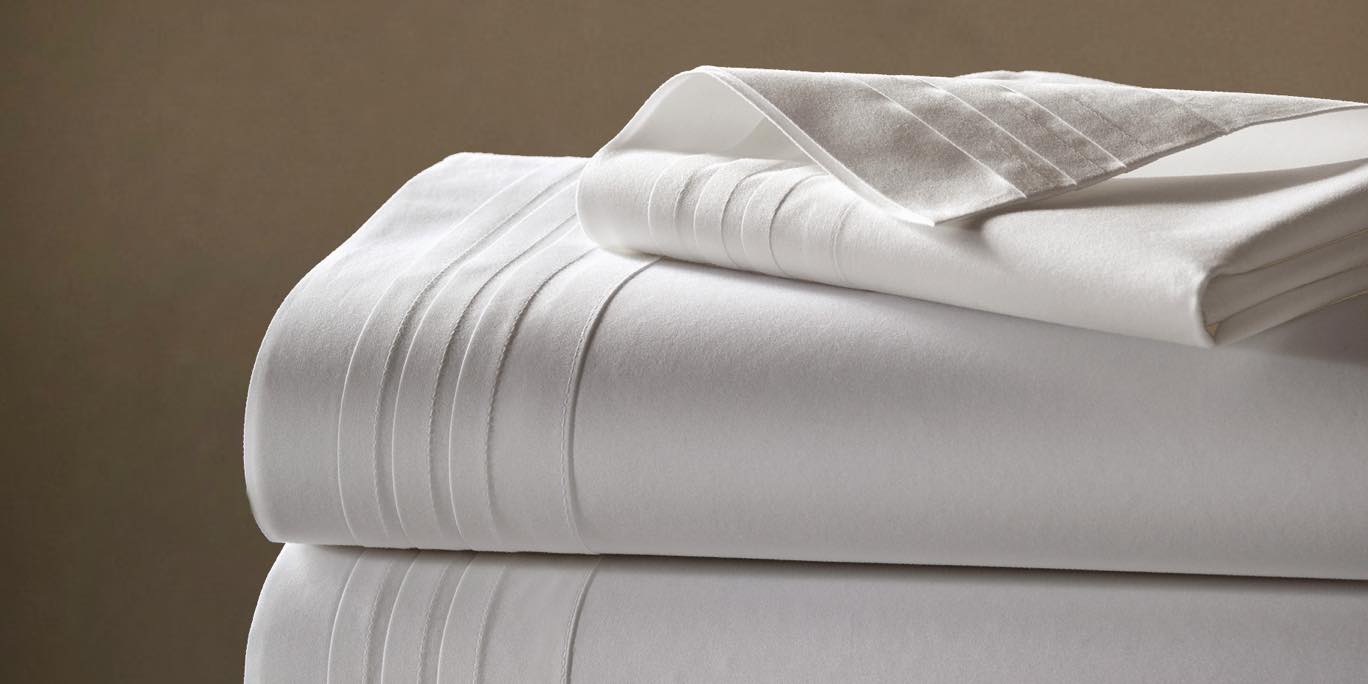 Close Up of Shirting and Sheeting fabric. Clean white fabric against natural brown background.